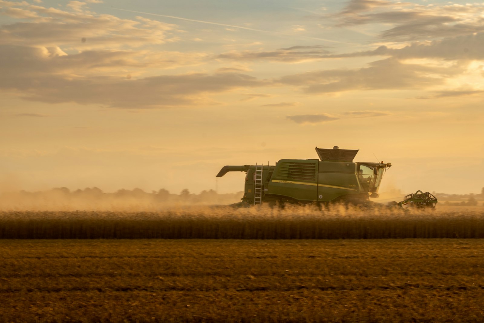 Colheitadeira colhendo grãos ao entardecer – crédito rural